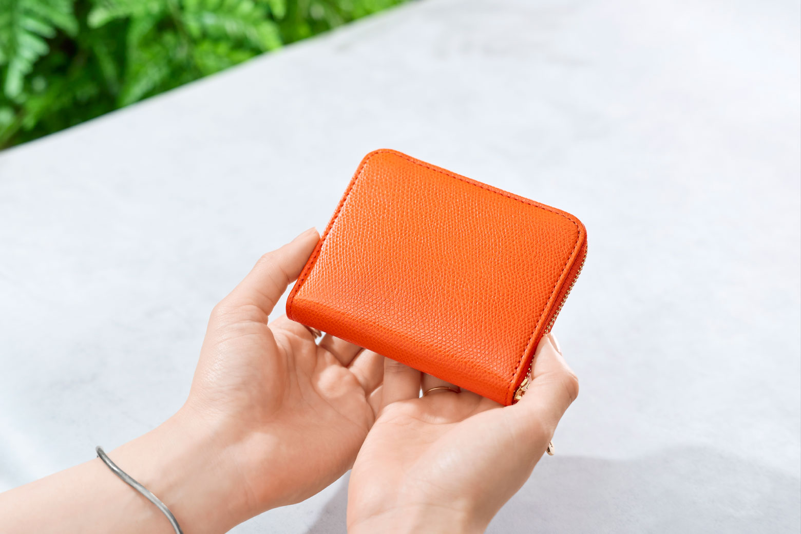 伊東屋　カラーチャート　ジップウォレットコンパクトを手に持っている