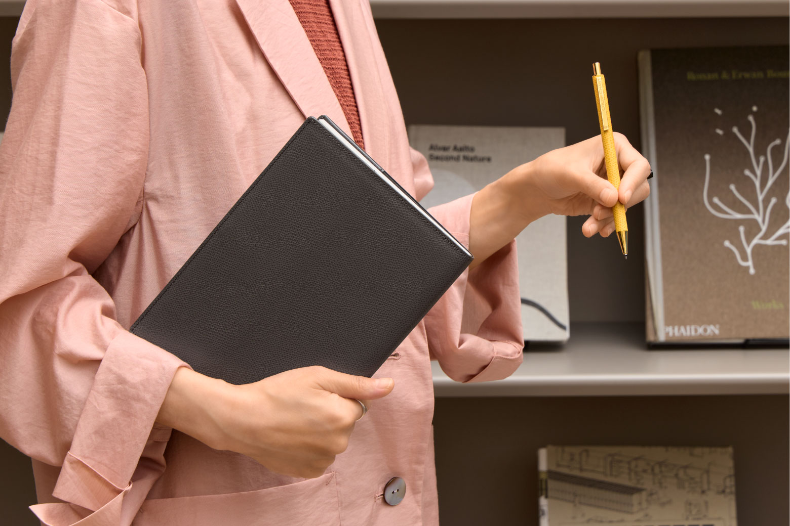 伊東屋　カラーチャート　ノートカバーA5と革巻きボールペンを持っている様子　